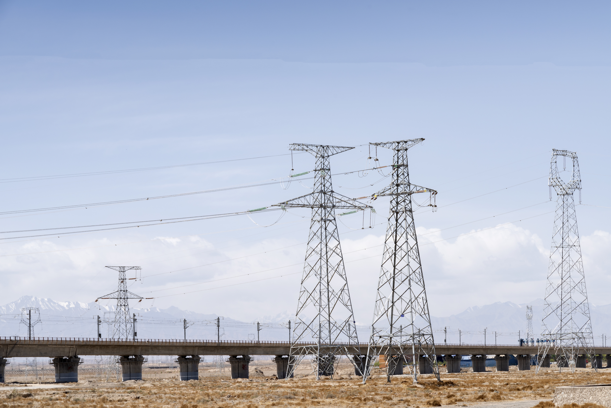 Highway and high voltage transmission towers in the sky background