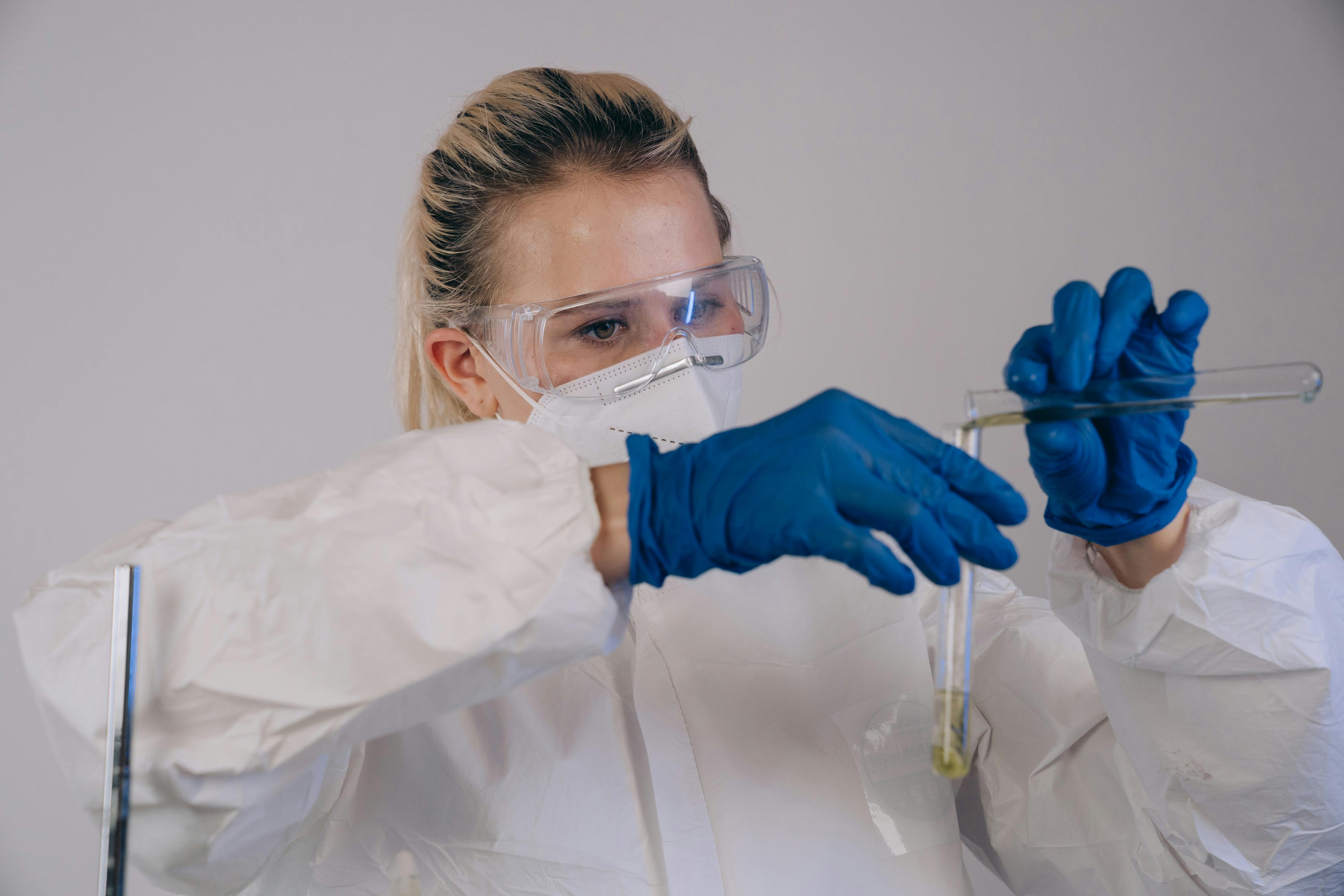 A doctor pouring liquid into a vial.