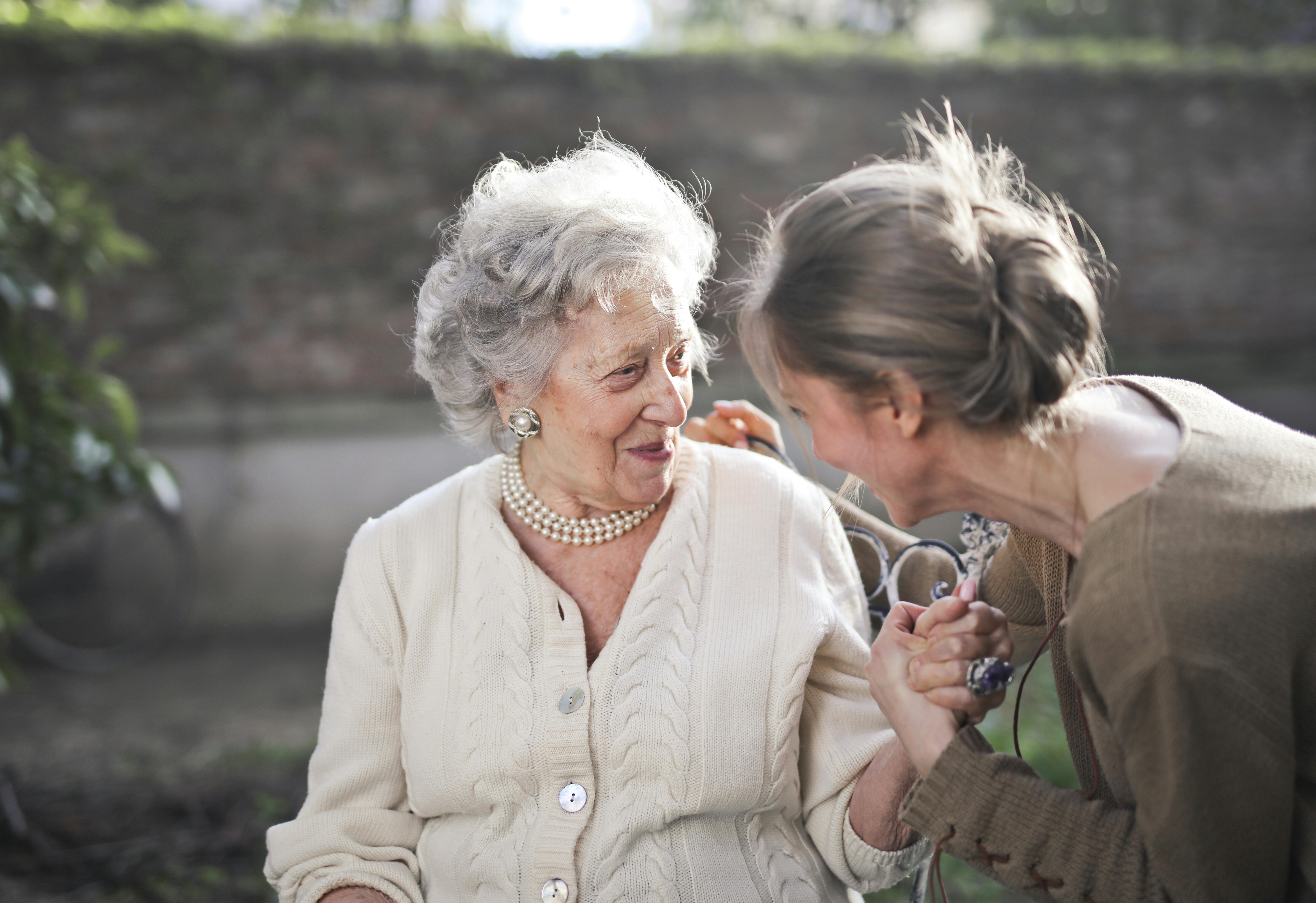 An older woman speaking to a younger woman.