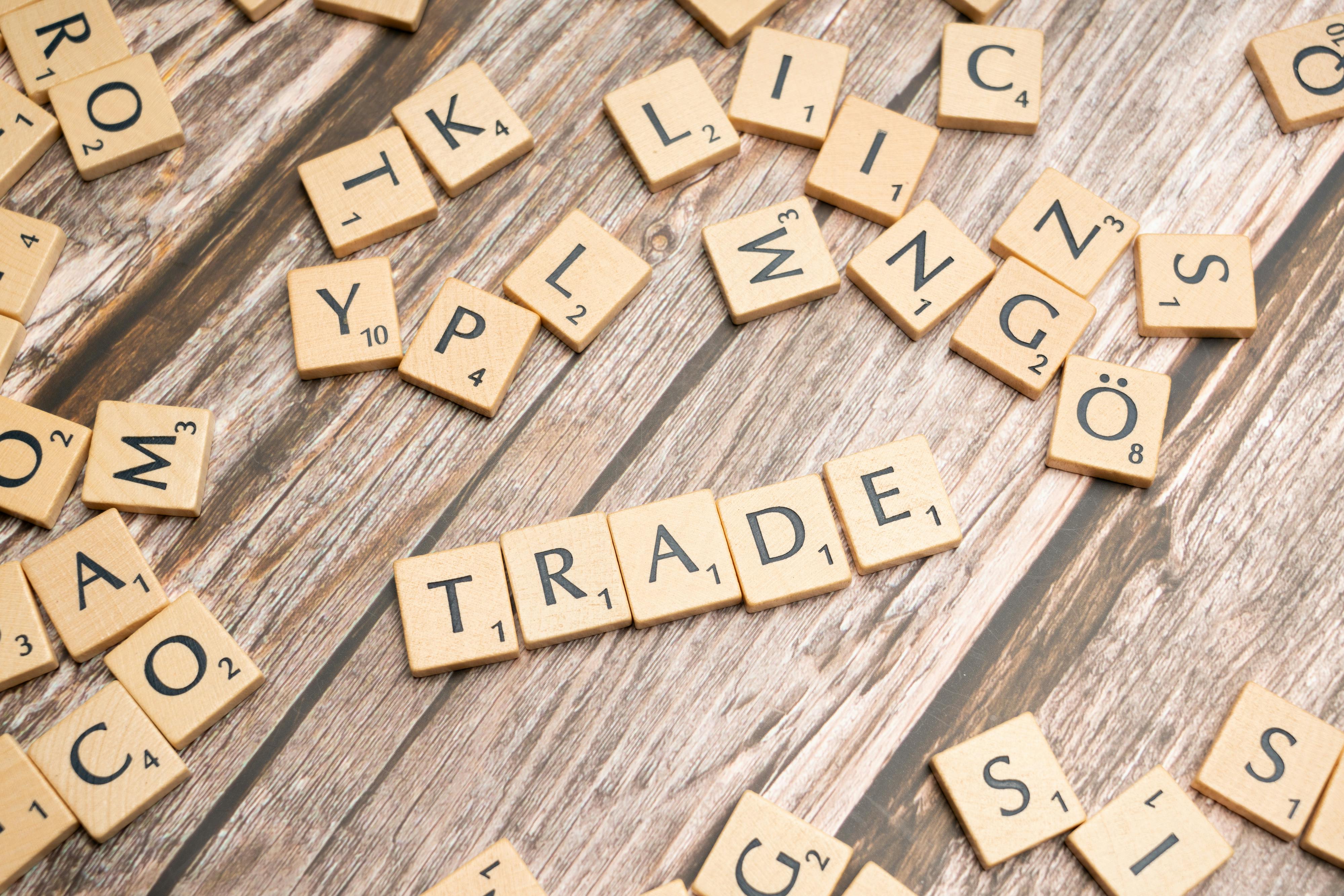 Scrabble letters spelling the word "trade."