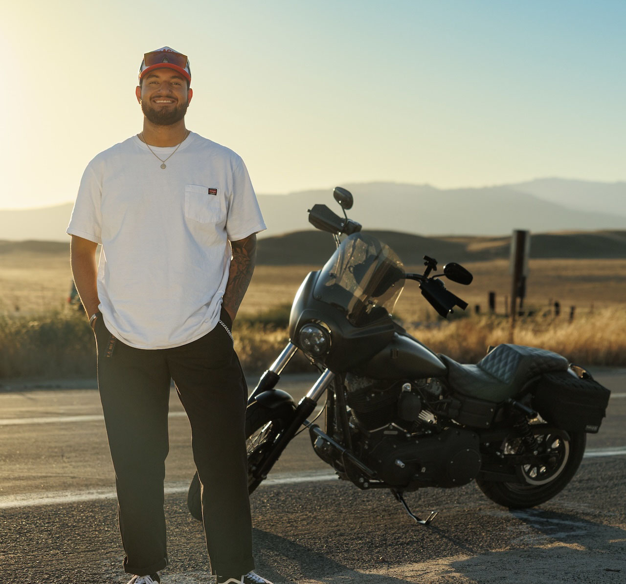 MACC alum Everson Wimer poses on the side of the road with his motorcycle